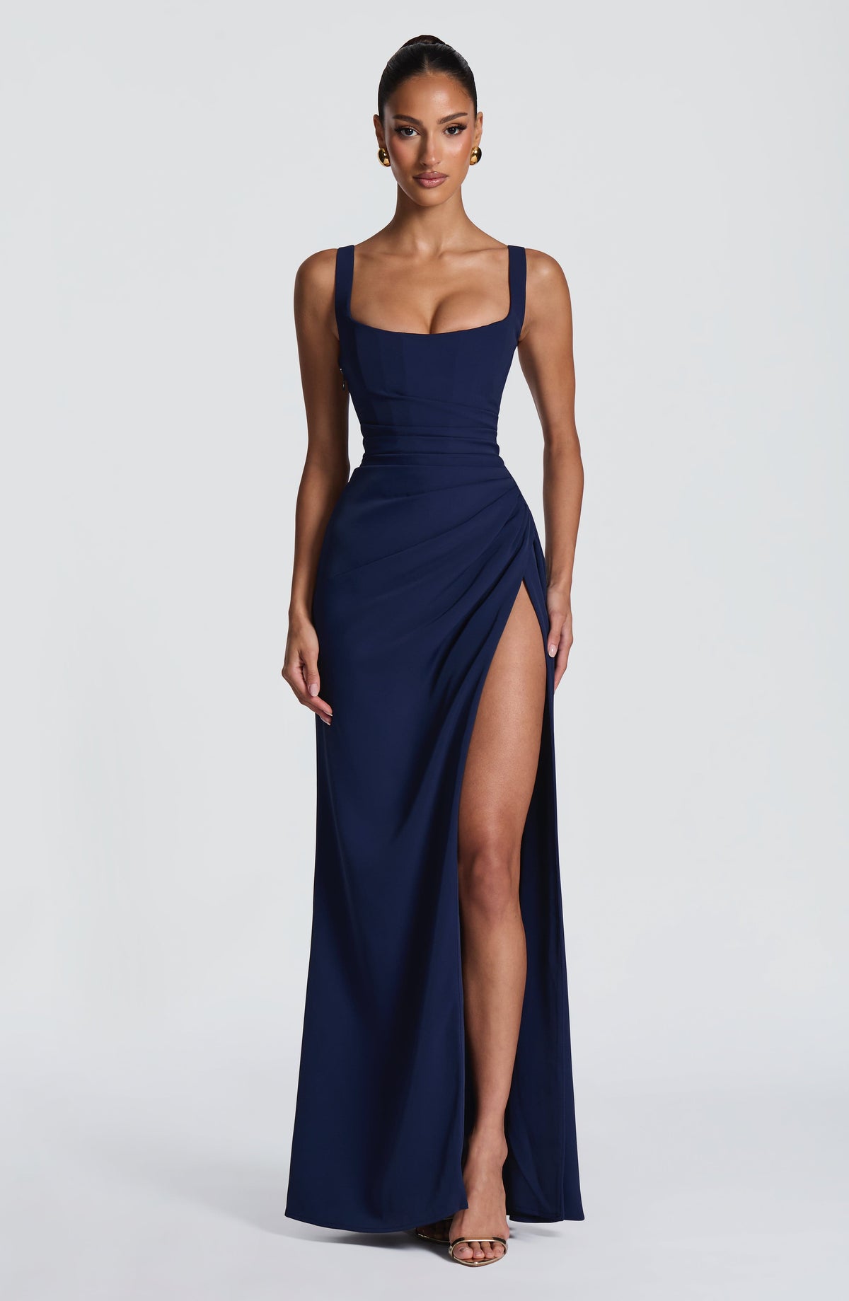 Navy maxi dress on a model standing front-on with arms relaxed, showing the high leg slit. 15