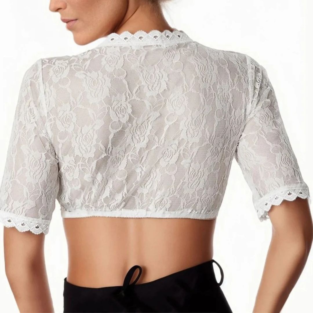 Back view on a model of the sheer white floral lace blouse, with scalloped neckline and sleeve edges, worn with a black skirt. 2