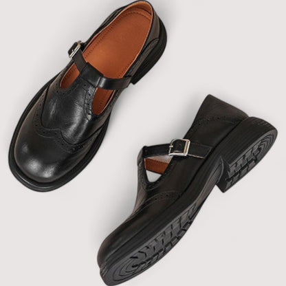Pair of black brogue Mary Janes from above, one showing the tan insole and strap, the other its tread sole. 5