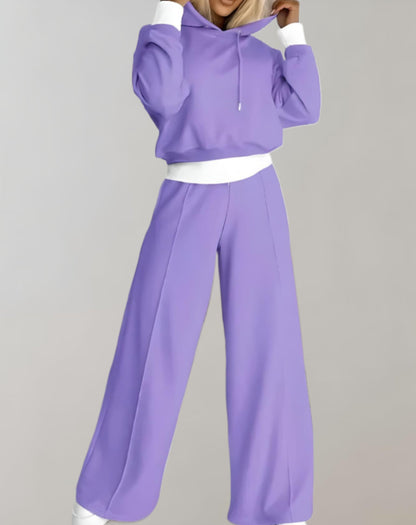 Model wearing the lilac set with white cuffs and waistband, hands raised to the hood, full-length front view. 2