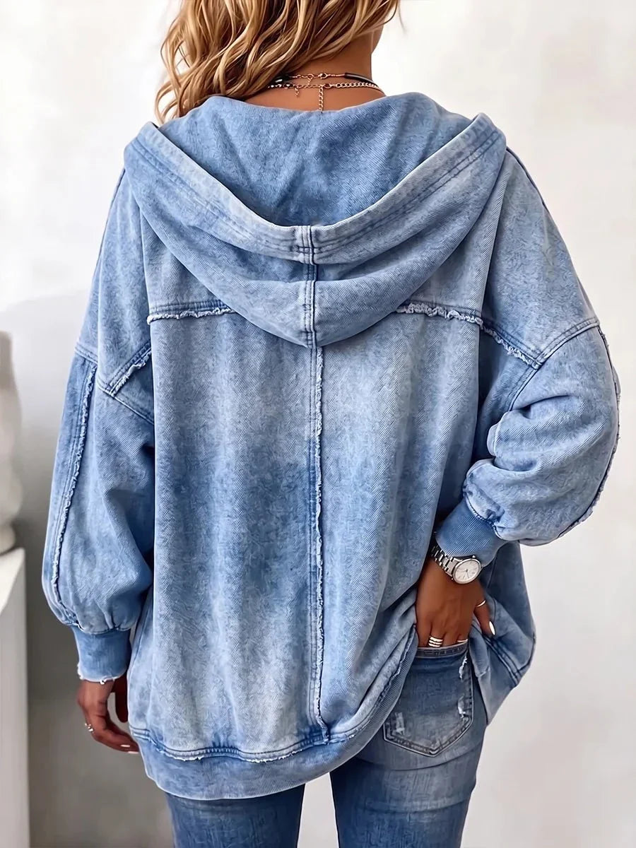Back view of the faded blue hooded jacket on a model, showing the centre seam, raw-edge stitching and ribbed cuffs. 2