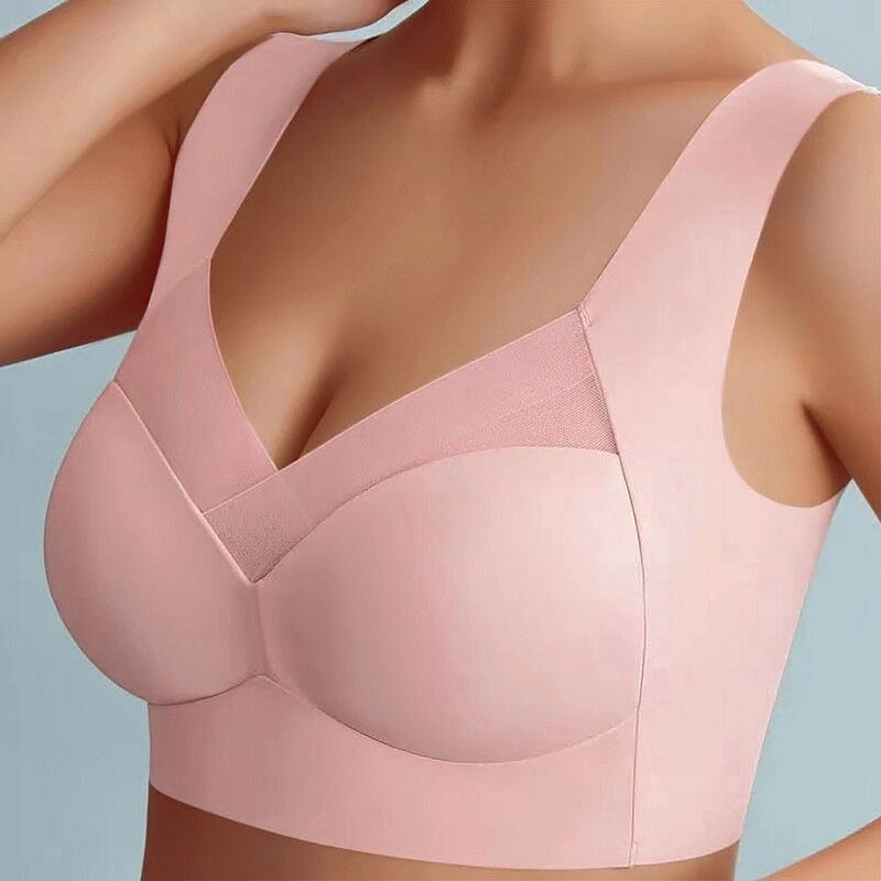 Model wearing the pink wide-strap bra from the front, showing the mesh neckline panel and smooth seamless cups. 7