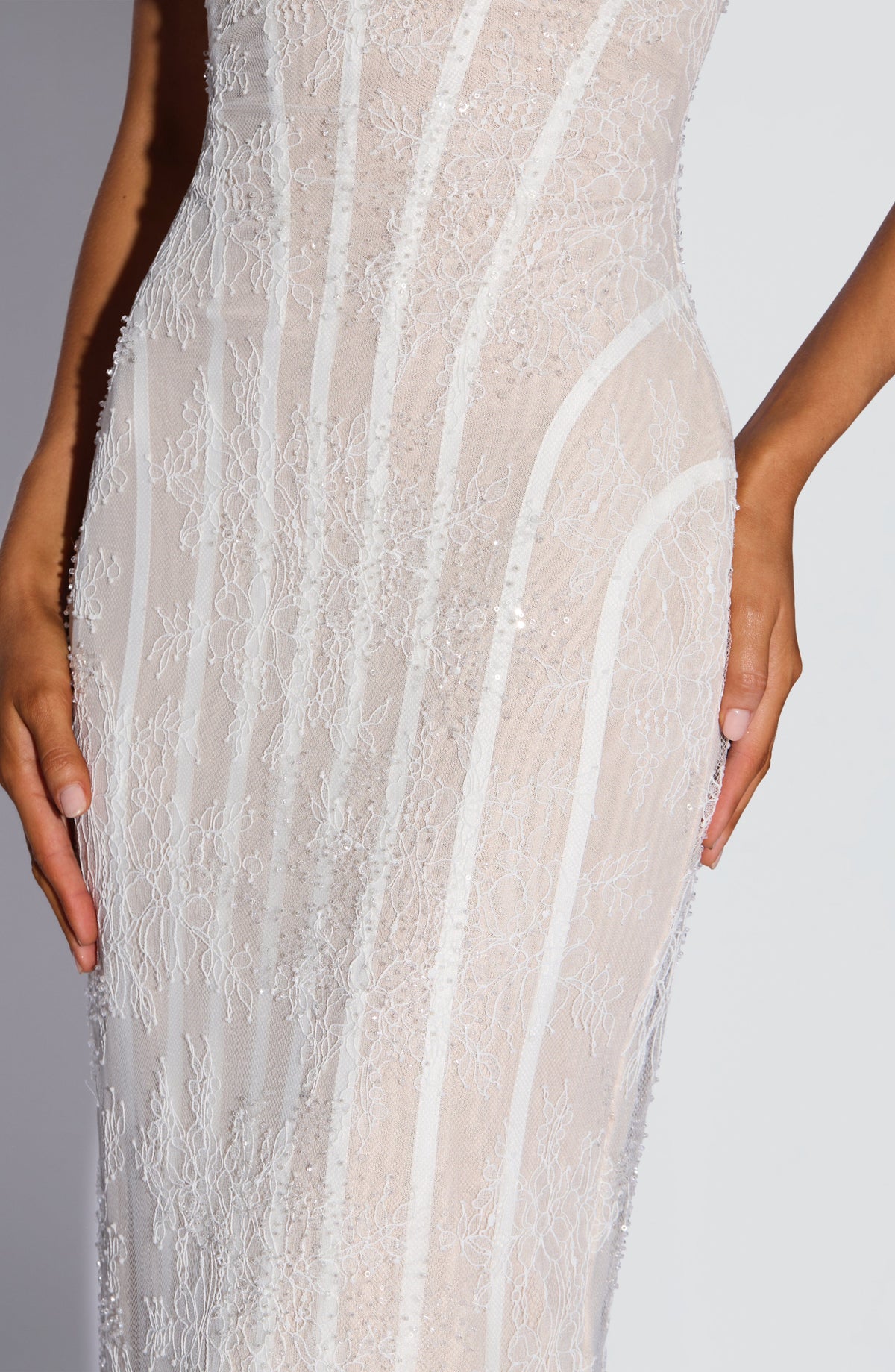 Close-up of the white lace midsection, showing the floral lace, small beads and sequins, and the curved boning lines over a nude lining. 12