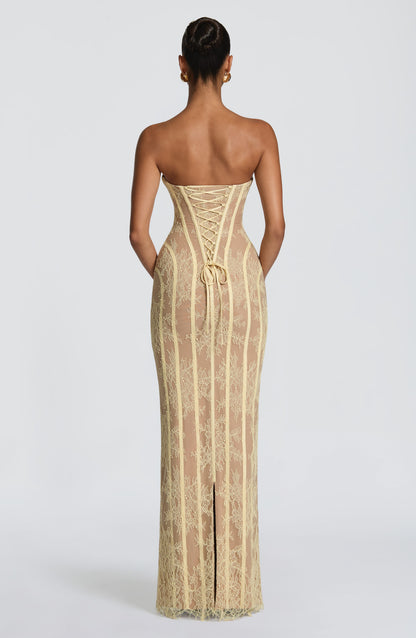 Back view of the pale yellow lace dress, showing the lace-up corset back, a tied bow and the centre slit at the hem. 18