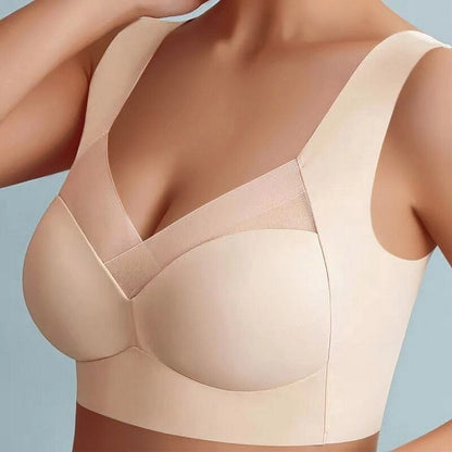 Model wearing the beige wide-strap bra from the front, showing the mesh neckline panel and smooth seamless cups. 6