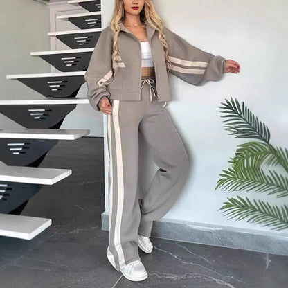 Grey set with cream stripes worn by a model leaning against a wall, loose sleeves and wide-leg trousers visible. 6