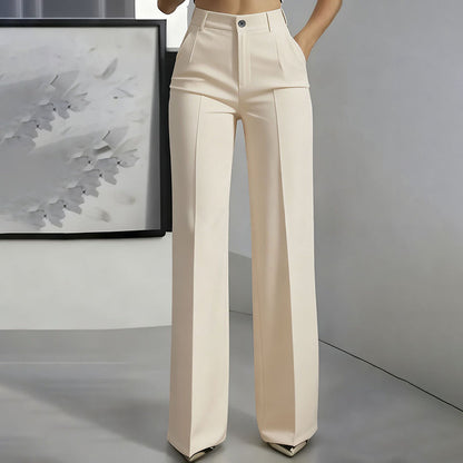 Front view of cream high-waisted straight-leg trousers with centre crease and button closure, worn by a model beside framed artwork. 5