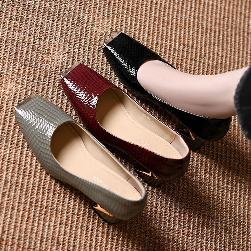 Top-down view of grey, burgundy and black snake-effect pumps side by side on a woven mat, showing the cream insoles. 6