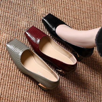 Top-down view of grey, burgundy and black snake-effect pumps side by side on a woven mat, showing the cream insoles. 6
