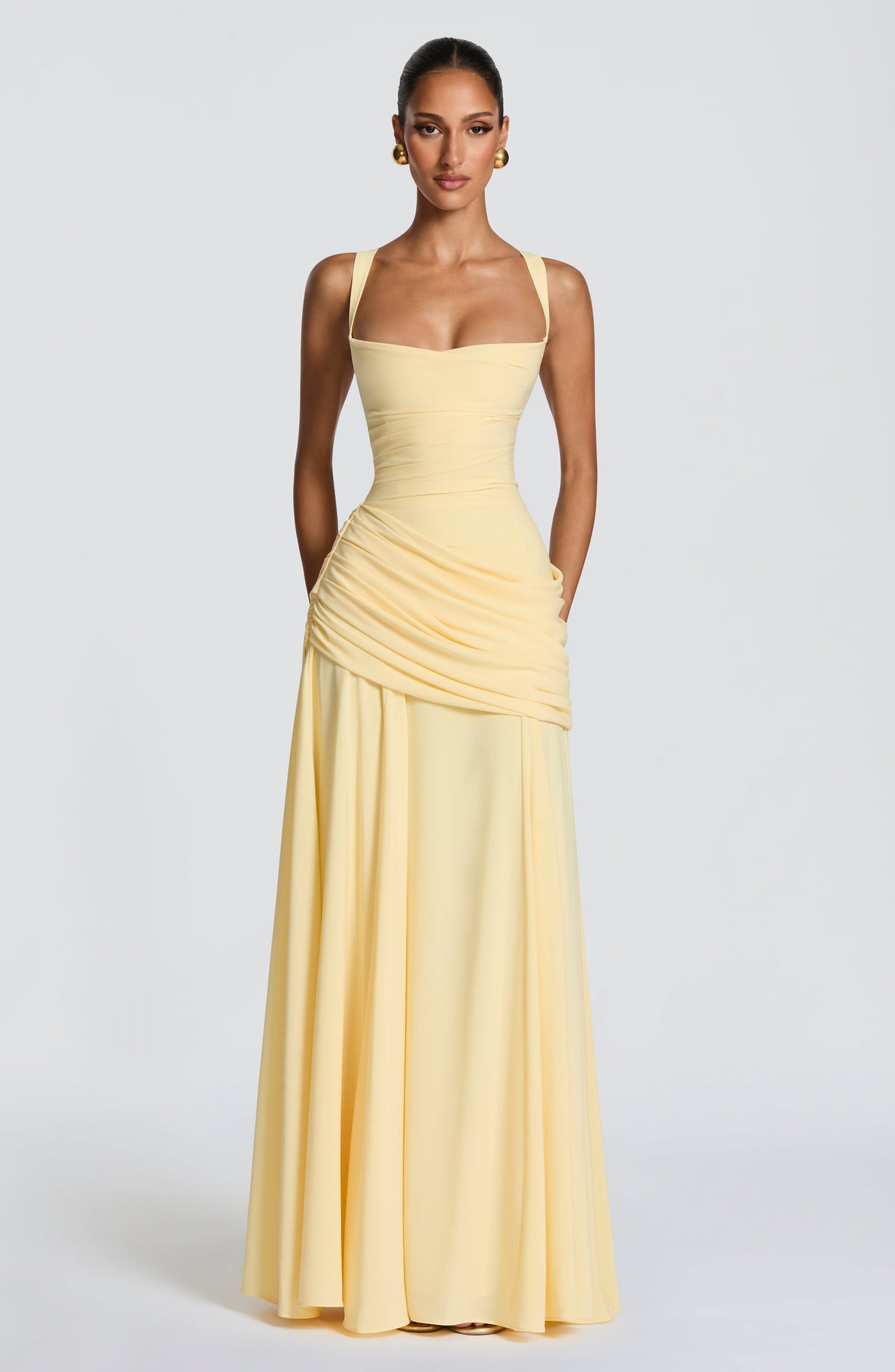 Full-length front view of the pale yellow dress on a model, hands behind her back, showing the skirt falling straight to the floor. 5