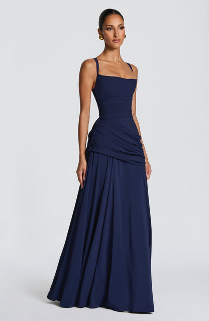 Side view of the navy dress with thinner straps, showing the squared neckline, ruched side seam and flared skirt. 12