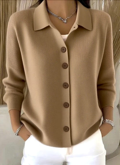 Model wearing the camel-beige version of the knit cardigan, front buttoned, with silver bracelets and a chain necklace. 3