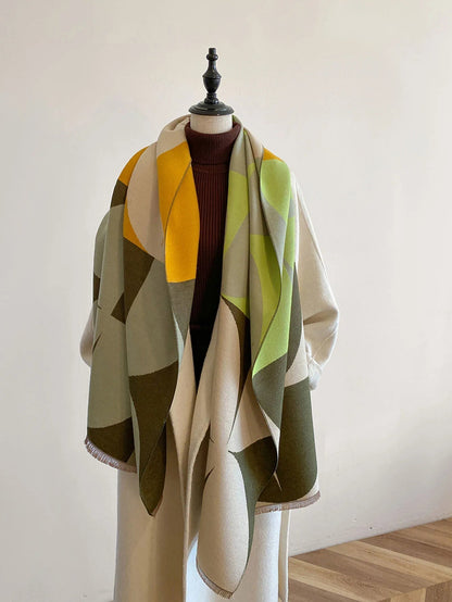 Scarf in yellow, lime green, olive and cream geometric blocks draped open over a mannequin with a burgundy polo neck. 4