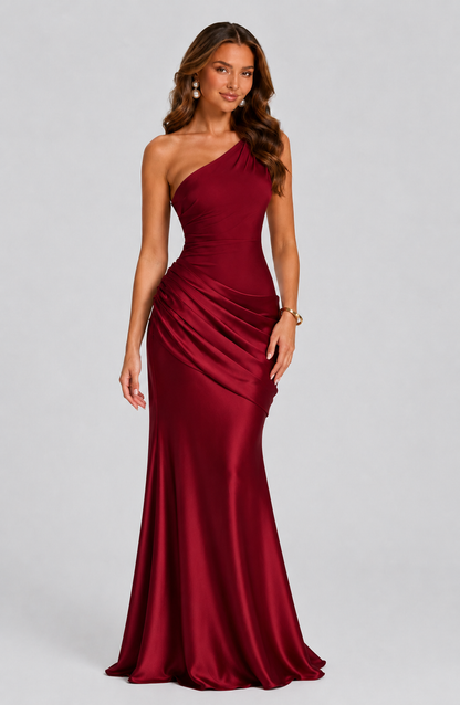 Deep red version, front view, worn with pearl drop earrings and a gold bangle, showing the pleated hip drape. 9