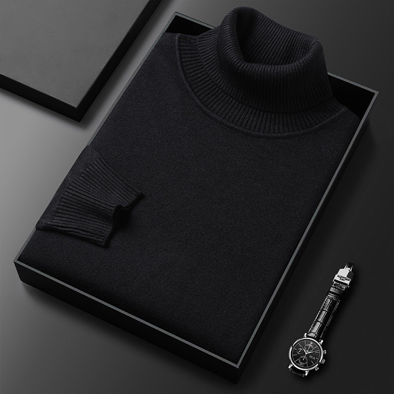 Folded black roll-neck jumper showing its ribbed collar and cuff in a dark box, with a wristwatch beside it. 3