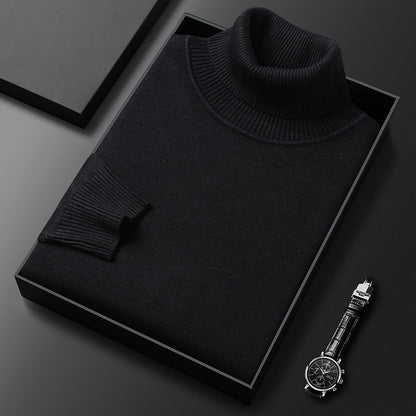 Folded black roll-neck jumper showing its ribbed collar and cuff in a dark box, with a wristwatch beside it. 3