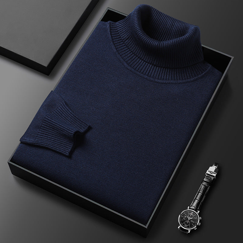 Folded navy roll-neck jumper with ribbed collar and cuff in a black gift box, a wristwatch at the corner. 4