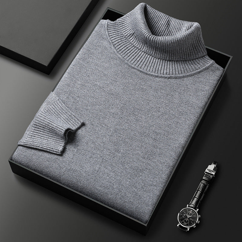 Folded grey roll-neck jumper with ribbed collar and cuff presented in a black box next to a wristwatch. 5