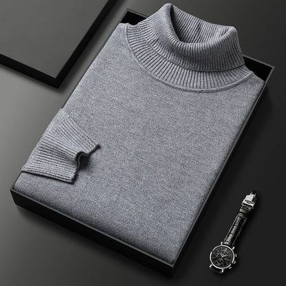 Folded grey roll-neck jumper with ribbed collar and cuff presented in a black box next to a wristwatch. 5