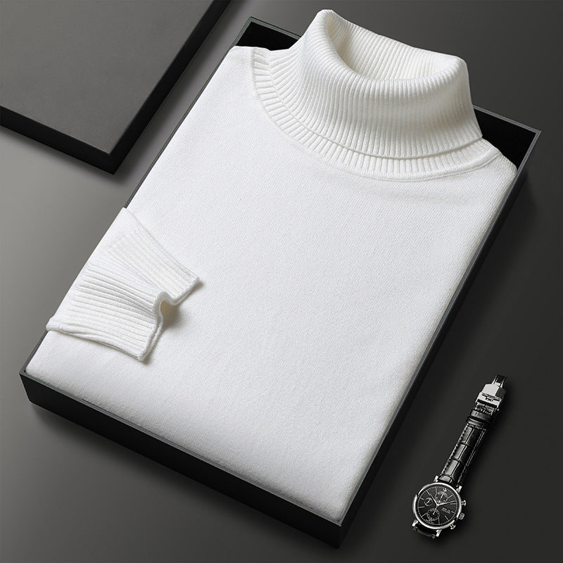 Folded white roll-neck jumper with ribbed collar and cuff in a black box, a wristwatch placed beside it. 6