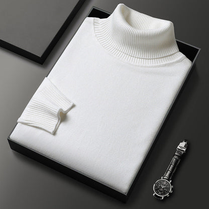 Folded white roll-neck jumper with ribbed collar and cuff in a black box, a wristwatch placed beside it. 6