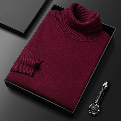 Folded burgundy roll-neck jumper with ribbed collar and cuff in a black box, with a black-strapped wristwatch nearby. 7