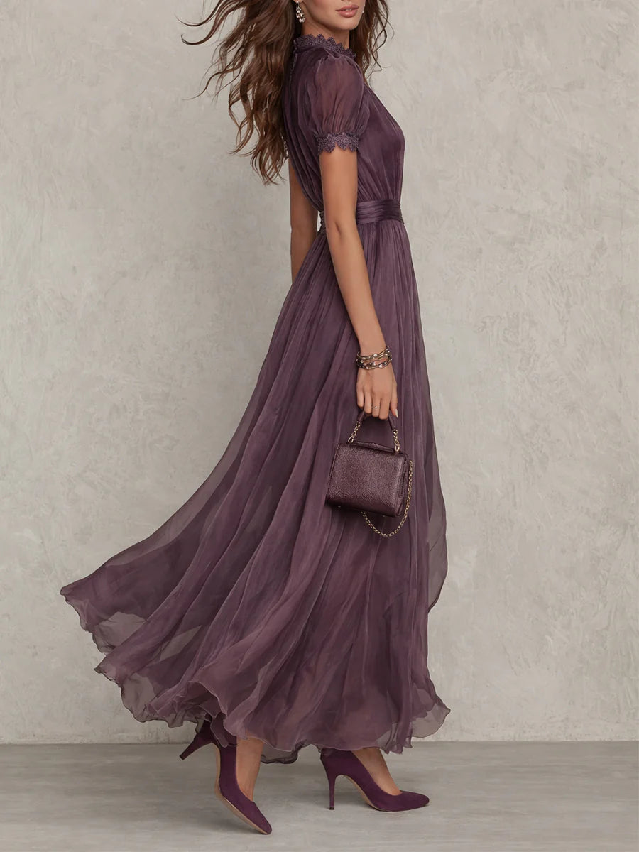 Side view of the model in the purple maxi dress, showing the puff sleeve with lace cuff and the full, floaty skirt. 2