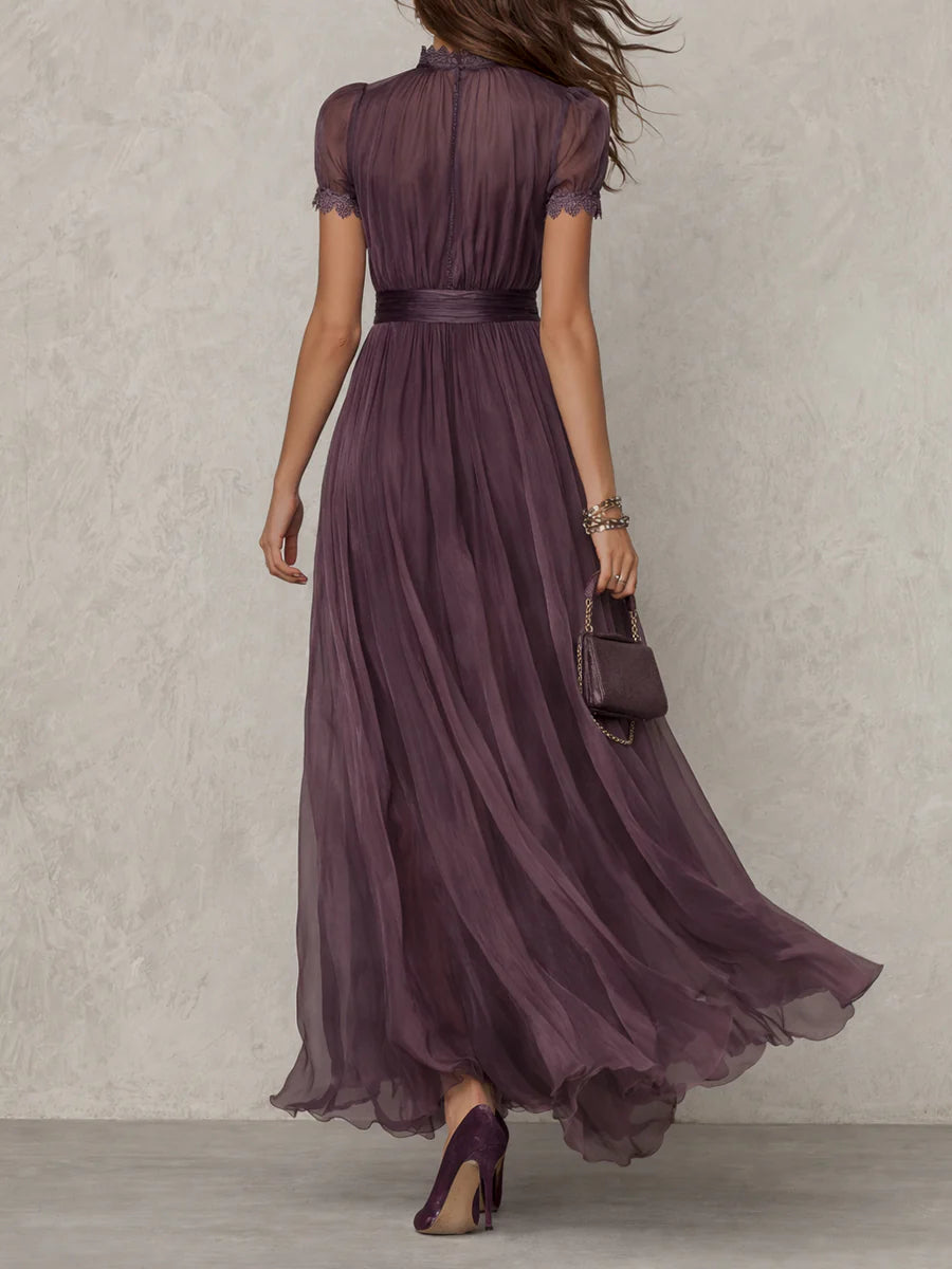 Back view of the purple maxi dress on a model, showing the buttoned back closure, lace-trimmed sleeves and gathered waistband. 3